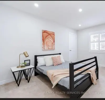 a bedroom with a bed and a table at Beautiful 4 bed 3 master bedrooms-pvt washrooms in Brampton