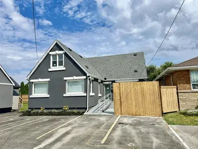 a house with a fence in a parking lot at Hamilton Chic Retreat - Cozy Winter Getaway in Hamilton