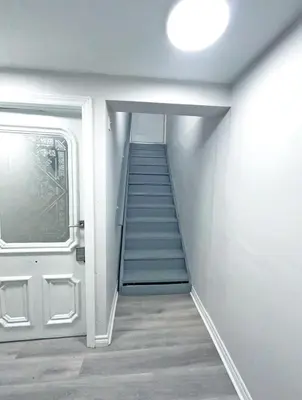 a staircase leading up to a door in a room at Hamilton Chic Retreat - Cozy Winter Getaway in Hamilton