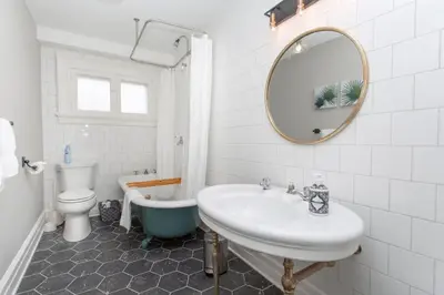 a bathroom with a sink and a tub and a toilet at Boutique Quality Home Downtown by the Shaw in Niagara on the Lake