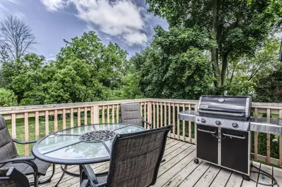 a patio with a table and a grill on a deck at Boutique Quality Home Downtown by the Shaw in Niagara on the Lake