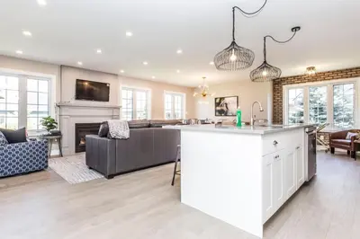 a large kitchen and living room with a fireplace at Boutique Quality in Old Towne with Hot Tub in Niagara on the Lake
