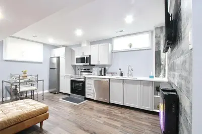 a kitchen with white cabinets and a table in it at Deluxe Apartment in Caledon