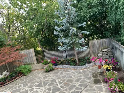 a garden with a fence and some flowers at Large private room in Mississauga