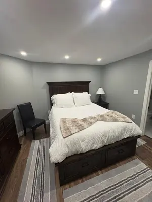 a bedroom with a large bed and a chair at Bolster in Uxbridge