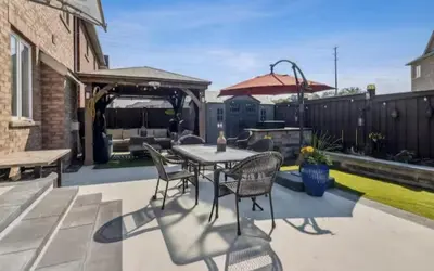 a patio with a table and chairs and a grill at Comfortable & Cozy 2BR Hideaway Basement Appartment in Brampton