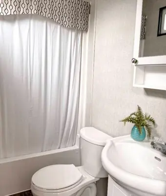 a white bathroom with a toilet and a sink at The Balmoral at Duck Lake in Carden