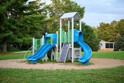 a playground with a blue slide in a park at The Balmoral at Duck Lake in Carden