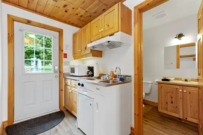 a kitchen with wooden cabinets and a white refrigerator at Port Cunnington Lodge in Dwight