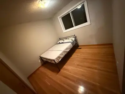 a small bed in a room with a window at HEAVY PRICE CUT-BOOK NOW!- Next to Airport, Downtown,Transit in Kitchener