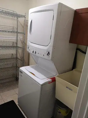a white dryer sitting on top of a refrigerator at Cozy Apartment Unit in London