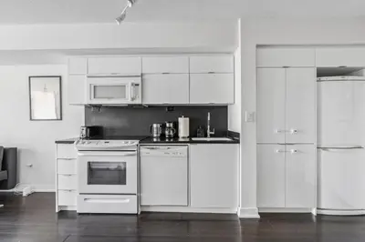 a kitchen with white appliances and white cabinets at Elegant Condo, Toronto Views , CityPlace Downtown in Toronto