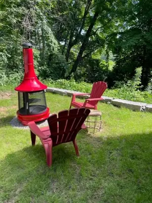 a red bird feeder and a chair in a yard at Wildwood Bunkies in Bailieboro