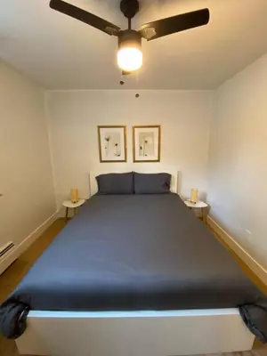 a bedroom with a large blue bed with two tables at ENTIRE 1 BEDROOM APARTMENT by UW RESEARCH PARK - PS1 in Waterloo