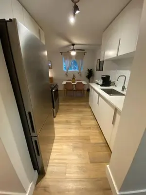 a kitchen with a stainless steel refrigerator and a table at ENTIRE 1 BEDROOM APARTMENT by UW RESEARCH PARK - PS1 in Waterloo
