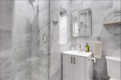 a bathroom with a shower and a toilet and a sink at Casa Hotel Stylish Suite with Patio in Leslieville in Toronto
