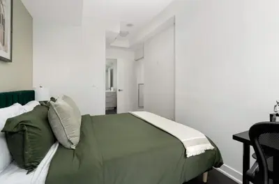 a bedroom with a green bed and a desk at 2BR 2BA Suite with Sofa Bed by Financial District in Toronto