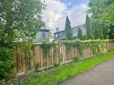 a wooden fence in front of a house at Garden Suite with Pool and Sauna in Brampton