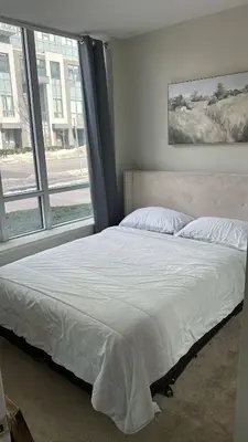 a bed in a bedroom with a large window at Private Cozy Room in Mississauga