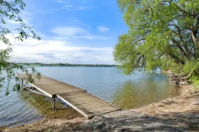 a wooden dock sitting on the side of a lake at The Merlin - 61 Butternut in Cherry Valley