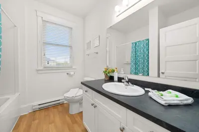 a white bathroom with a sink and a toilet at The Copper - 11 Butternut in Cherry Valley