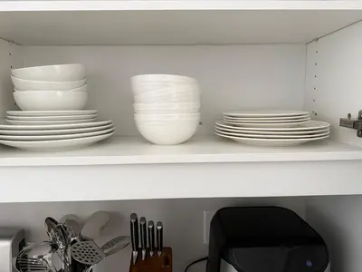 a white shelf with plates and dishes on it at Cozy 3 Bedroom Townhome Hyde Park Mall & Western University in London