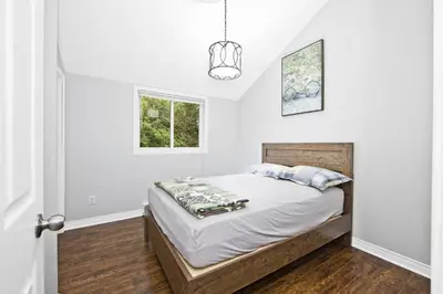a bedroom with a bed and a window at PRIVATE COTTAGE GETAWAY On LAKE SIMCOE in Brechin