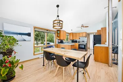 a kitchen and dining room with a wooden table and chairs at PRIVATE COTTAGE GETAWAY On LAKE SIMCOE in Brechin
