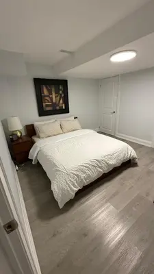 a bedroom with a large white bed in it at Brand new 2 bedroom basement apartment in Ajax