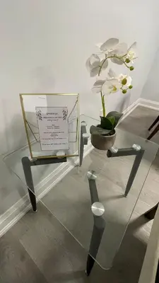 a glass table with a vase with a white flower on it at Brand new 2 bedroom basement apartment in Ajax