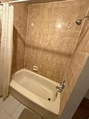 a white bath tub in a bathroom with a shower at Upper Level Cheap Room For 3 People- 24 Hrs Checkin-Walking to Bus,Grocery, Plaza in Kitchener