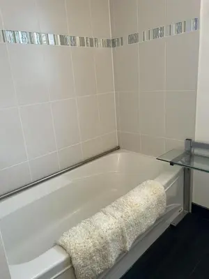 a white bath tub with a towel sitting on it at Cozy Room for Two Unionville Area Twin Beds or King Minimum Stay 30 Days in Markham