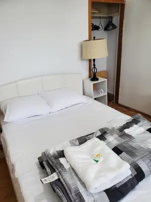 a bed with two towels and a blanket on it at Toronto Little Italy Guest House in Toronto