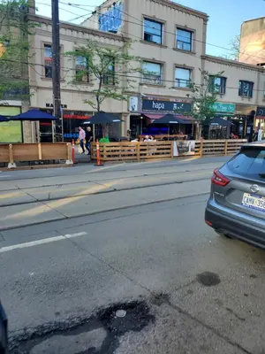 a street with a car parked in front of a building at Toronto Little Italy Guest House in Toronto