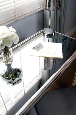 a glass table with a vase of flowers on a window at The Breadalbane Inn in Fergus