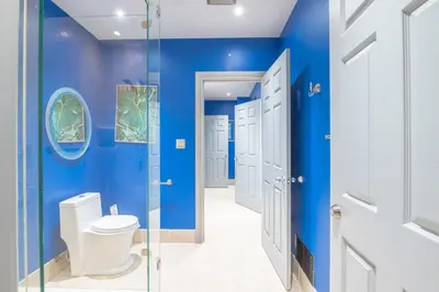 a bathroom with blue walls and a toilet at Lux Lakeside Escape Slps 20 with Pool, Golf Sim, Hot Tub, Karaoke, Gym and Sauna in Peterborough