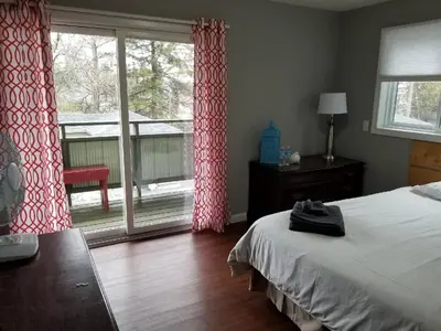 a bedroom with a bed and a large window at Westlake Cottage - Hillier Lodge in Wellington