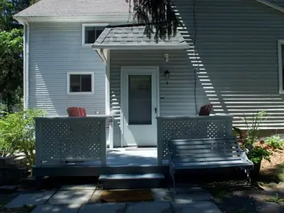 two benches sitting in front of a house at Westlake Cottages - Tulip Tree in Wellington