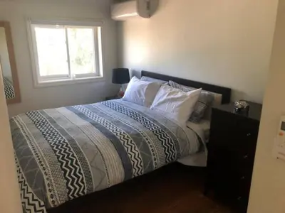 a bedroom with a bed with a window at Westlake Cottages - Tulip Tree in Wellington