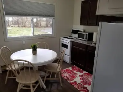 a kitchen with a white table and a white refrigerator at Westlake Picton Cottage in Wellington