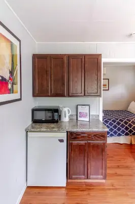 a kitchen with a counter and a refrigerator and a bed at Westlake Cherry Valley Cottage in Wellington