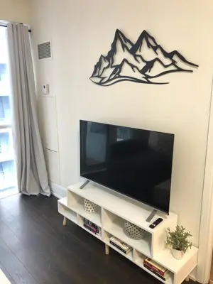 a flat screen tv sitting on top of a white entertainment center at Chic Toronto Blue Jays Getaway in Toronto