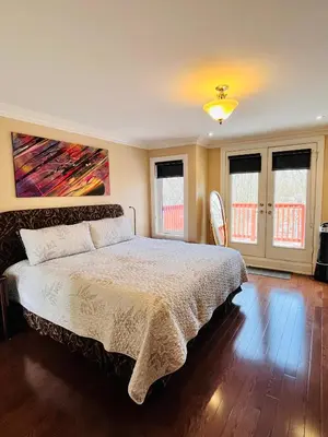 a bedroom with a bed and two chairs in it at Luxury Home - Upper Toronto Beaches in Toronto