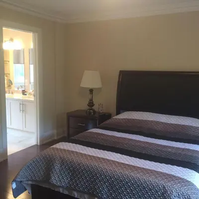 a bedroom with two beds and a table with a lamp at Luxury Home - Upper Toronto Beaches in Toronto