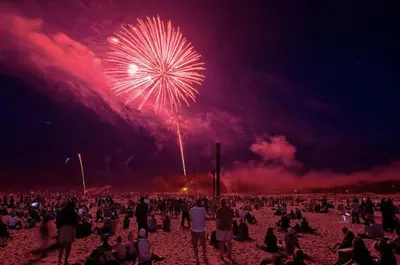 a crowd of people sitting on the beach watching fireworks at Luxury Home - Upper Toronto Beaches in Toronto