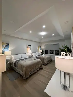 a large bedroom with two beds and a television at French Style Mansion In Prestigious Angus Glen Markham in Markham