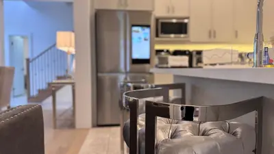 a kitchen with a chair and a counter with a refrigerator at French Style Mansion In Prestigious Angus Glen Markham in Markham