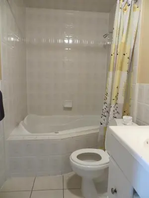 a bathroom with a tub and a toilet and a sink at Villa Nova Motel in Wasaga Beach