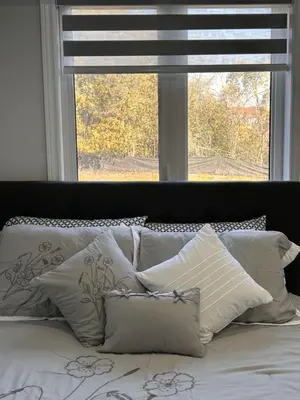 a bed with white pillows in front of a window at Whitby Hideout - 3BR, 5BD, 3WR, Pool Table, Sauna in Whitby