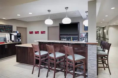a bar with wooden stools at a restaurant at @HOME by Best Western Walkerton in Walkerton